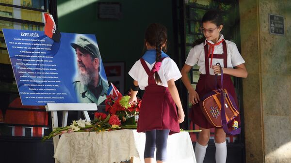 Дети возлагают цветы к портрету Фиделя Кастро у входа в школу в Гаване