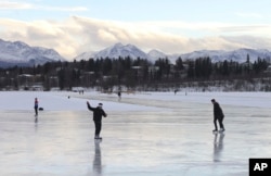FILE - In this Jan. 2, 2018, file photo, ice skaters take advantage of unseasonable warm temperatures to ice skate outside at Westchester Lagoon in Anchorage, Alaska.