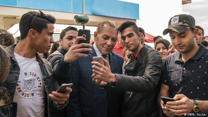 Men ask for selfies with Atatürk impersonator Göksal Kaya on a street in Izmir, Turkey.(DW/B. Secker)