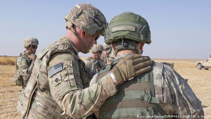 A US troop pats another troop on the back (picture-alliance/ZUMAPRESS/Staff Sgt. A. Goedl)